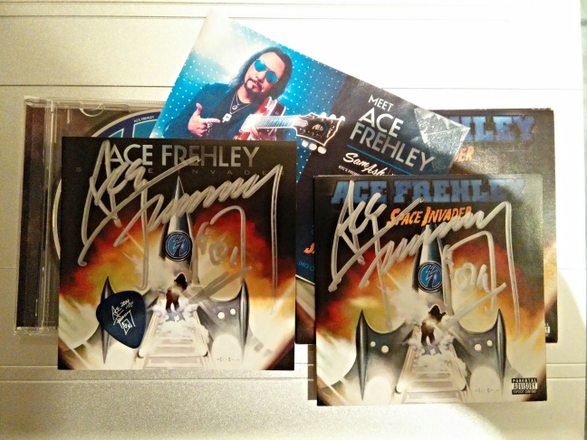 Indoor photo of autographed Ace Frehley album covers.
